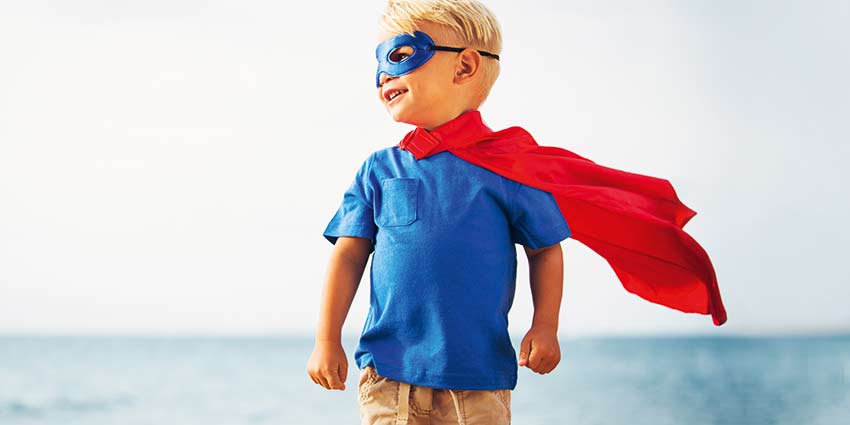 Young boy in hero clothing glancing to the horizon