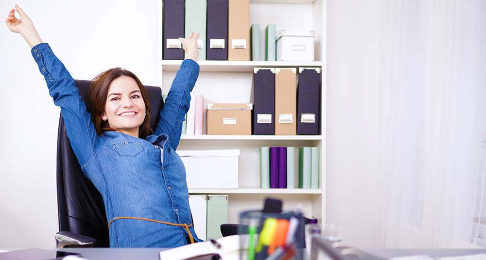 Woman in office relaxing and smiling in her chair